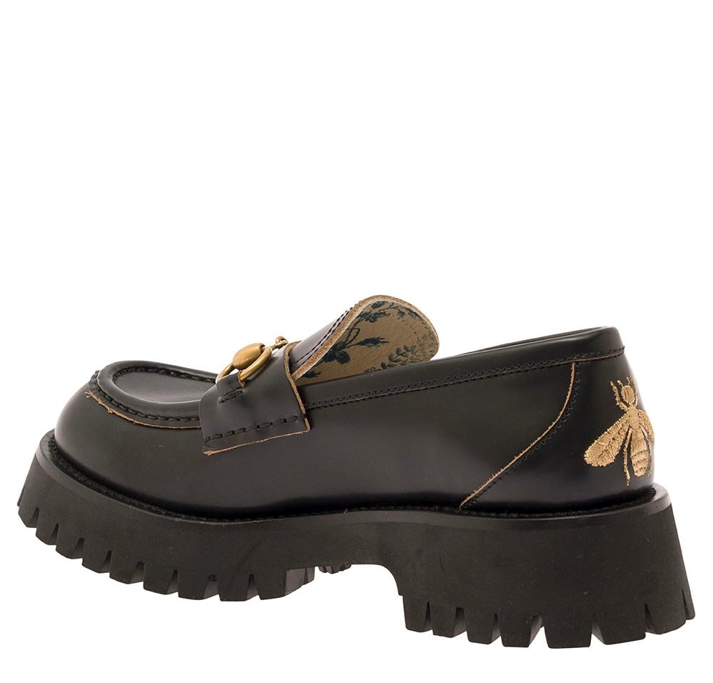 Gucci women’s black leather lug sole loafers